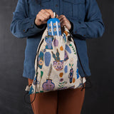 Sac à dos compact - Still Life, objet décoratifs, vases, plantes, visage, mauve, bleu, orangé sur fond beige clair, lifestyle