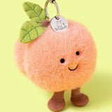 Jellycat - Breloque Pêche Amuseables Peach Bag Charm - APEACH4BC - Debout Sur Fond Jaune