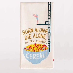 Linge à vaisselle "Born alone, die alone, in the middle Cereal !" plié sur fond blanc